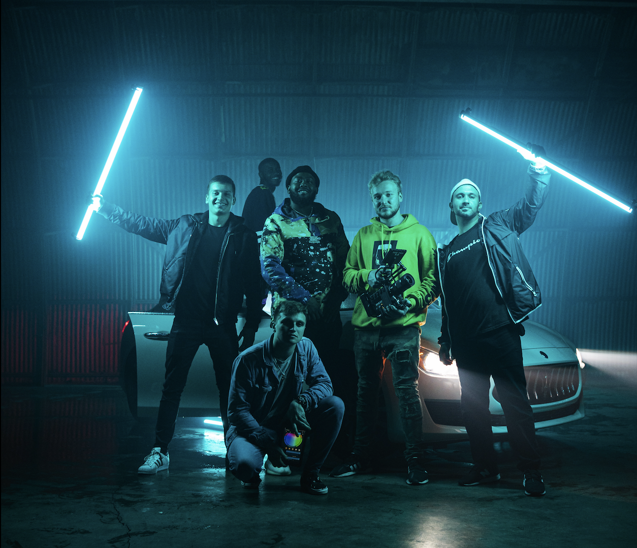 FogLine Visuals crew posing with LED tubes in a garage