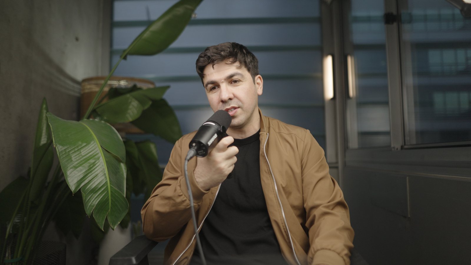 Artin Bogdanov, CEO of SUN, handheld mic, darker set, filmed by FogLine Visuals at its SoMa studio in San Francisco