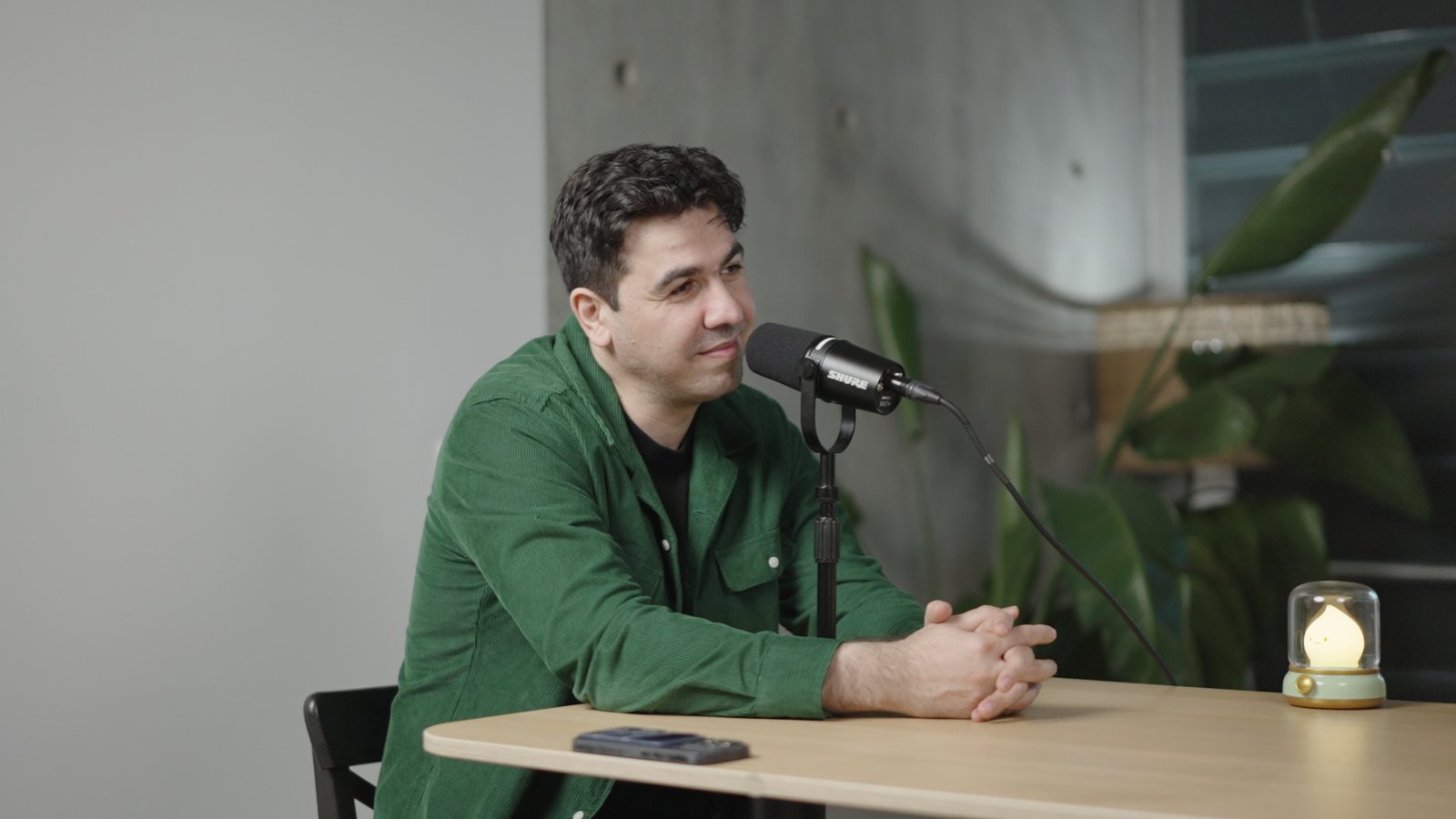 Artin Bogdanov, CEO of SUN, podcast mic at the desk, side angle, filmed by FogLine Visuals at its SoMa studio in San Francisco